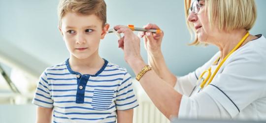 Lekarka diagnozuje zapalenie ucha u dziecka.