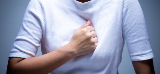 Kobieta odczuwa ból w klatce piersiowej, który może być objawem zatoru płucnego.