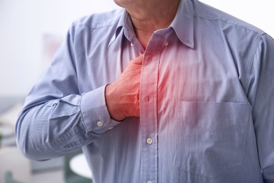 Mężczyzna chwyta się za klatę piersiową, cierpi na zespół Barlowa.