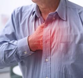 Mężczyzna chwyta się za klatę piersiową, cierpi na zespół Barlowa.