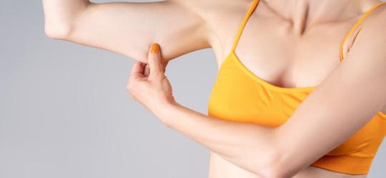 Kobieta naciąga wiotką skórę swojego zamienia.