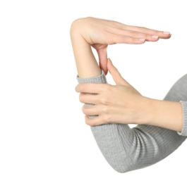 Kobieta przyciąga kciuk do przedramienia.